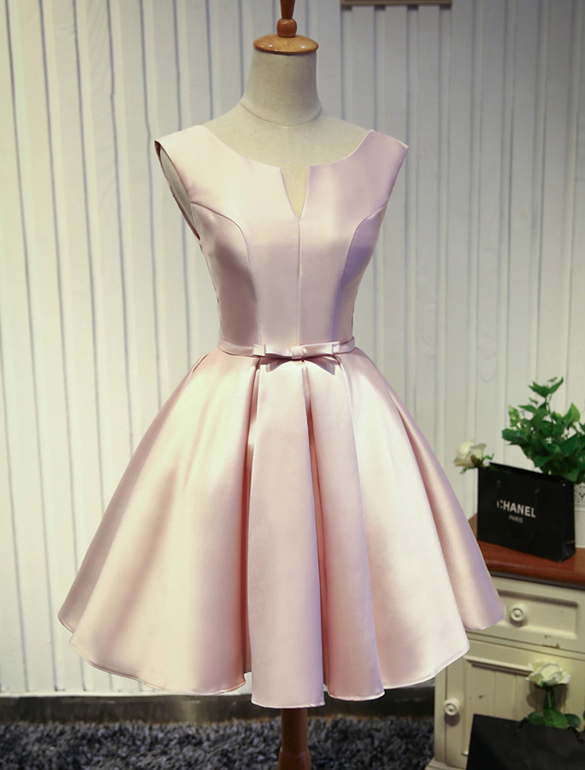 Close-up of the butterfly detail on a jewel neck satin dress.