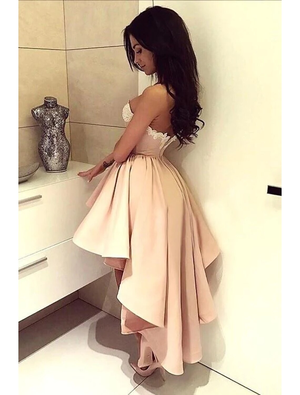 Side view of an A-line satin cocktail dress, highlighting the asymmetrical hem and flowing skirt.