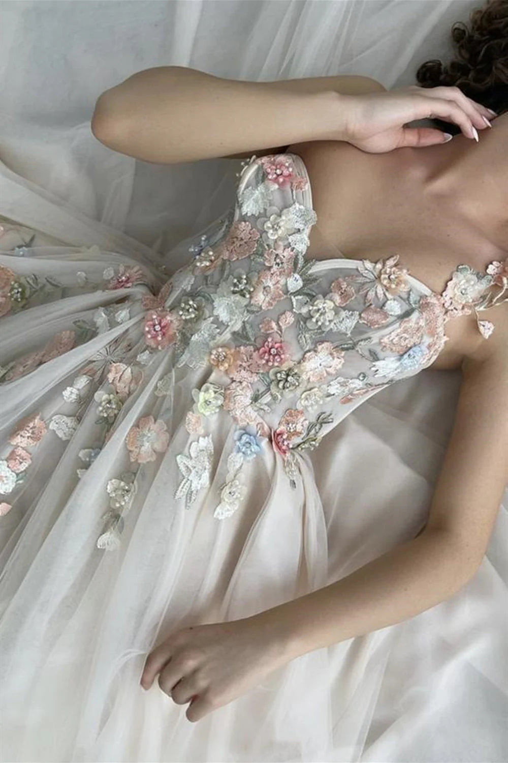 Vestido de fiesta largo color champán con un hombro descubierto y abertura con flores