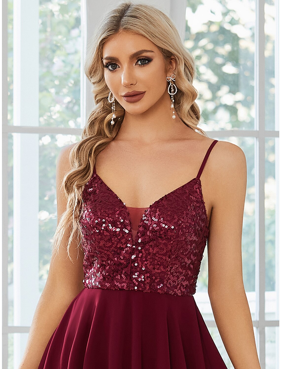 Model posing in the sleeveless A-line homecoming dress.