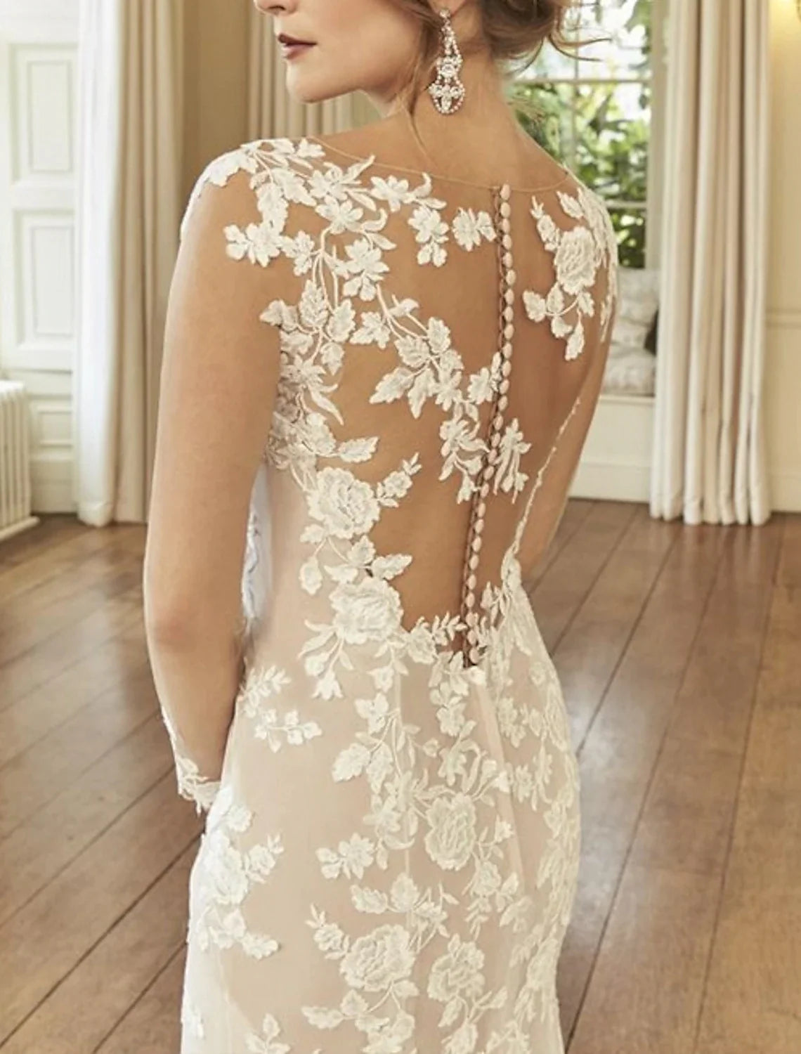 Side view of the elegant bridal gown, highlighting the mermaid silhouette and long sleeves.