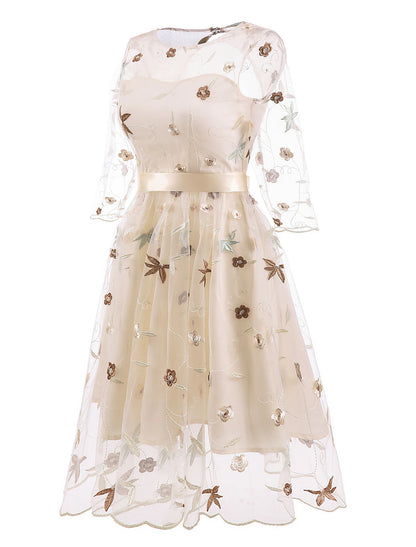 Close-up of floral embroidery and tulle fabric on a cocktail dress.