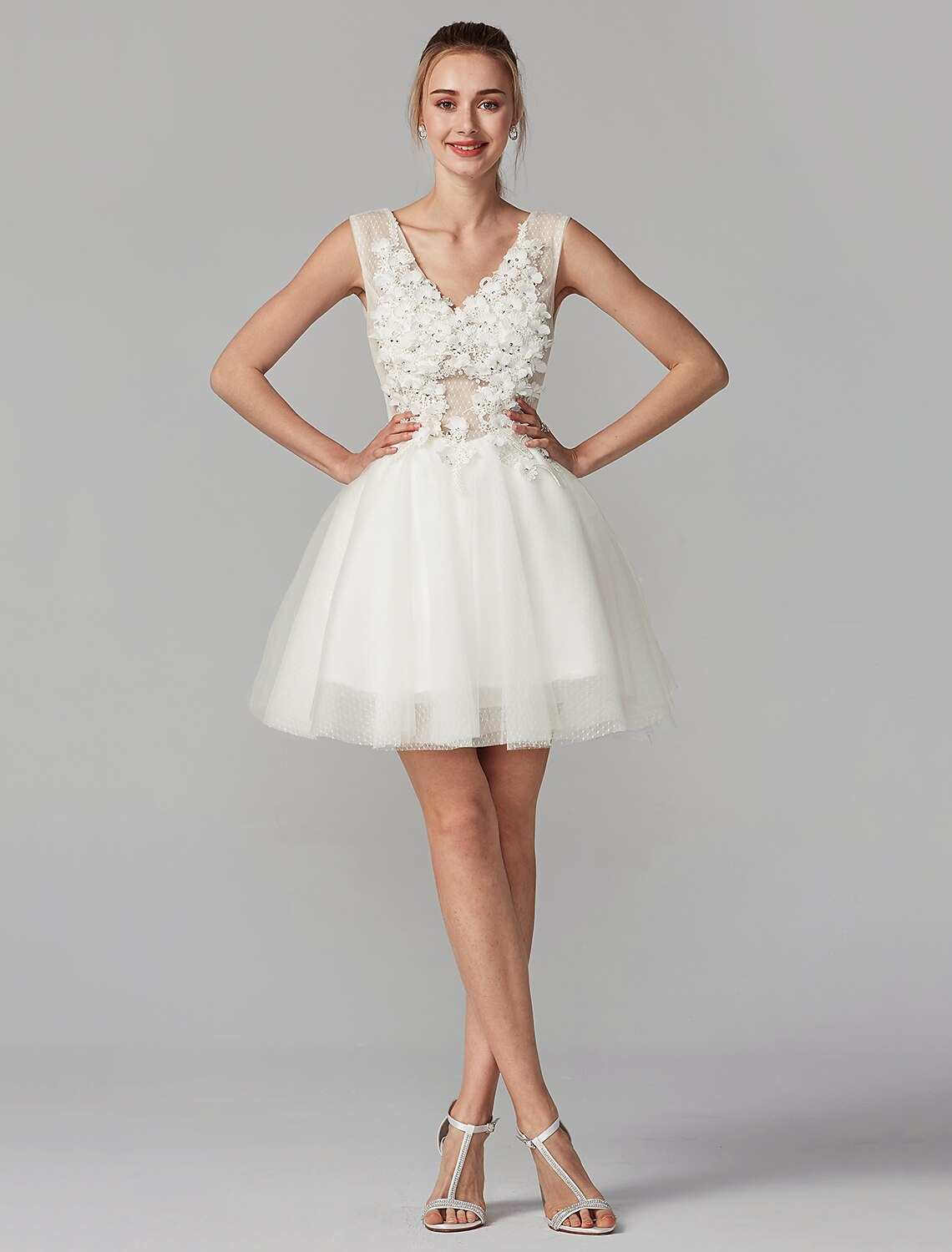 Model posing in a short A-line dress, showcasing the full design and flow of the tulle skirt.