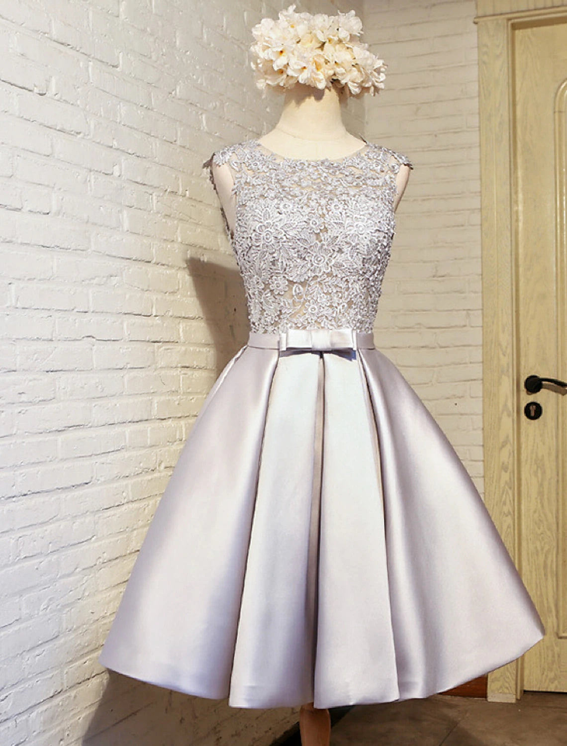 Front view of an A-line lace homecoming dress with a jewel neck and butterfly detail.