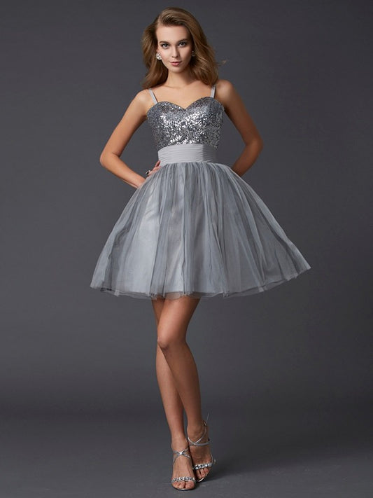 Model wearing a short A-line organza homecoming dress with spaghetti straps.