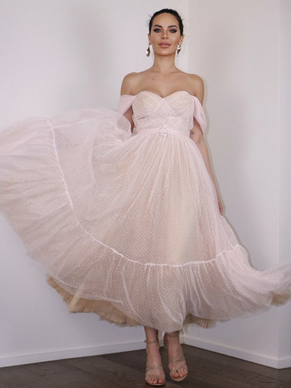 Side view of an A-Line lace off-shoulder tea-length homecoming dress with ruched details.