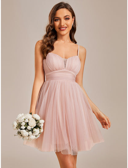 Model wearing a light blue A-line short tulle homecoming dress with spaghetti straps and ruched bodice.