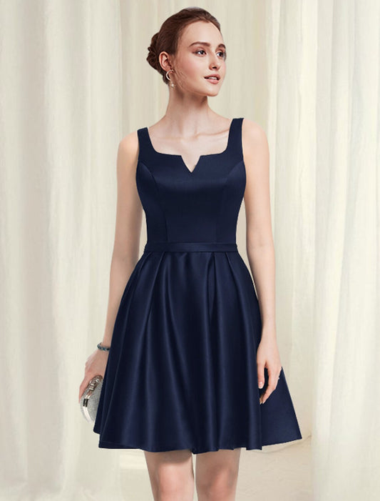 Model wearing a black A-line satin cocktail dress with a scoop neck and pleats.