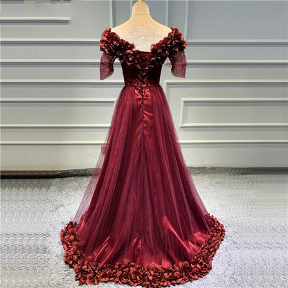 Vestido de fiesta largo color granate con hombros descubiertos y mangas cortas con abertura 