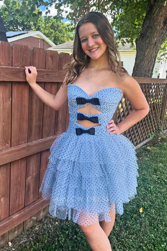 Back view of light blue polka dot short dress with tiered ruffle skirt.