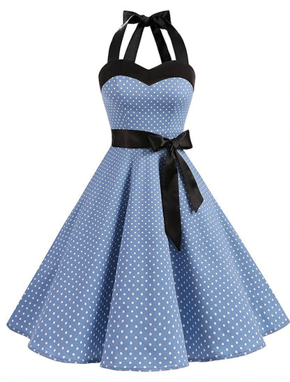 Woman wearing a black polka dot halter neck flare dress, back view.