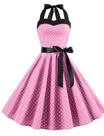 Woman wearing a red polka dot halter neck flare dress, front view.