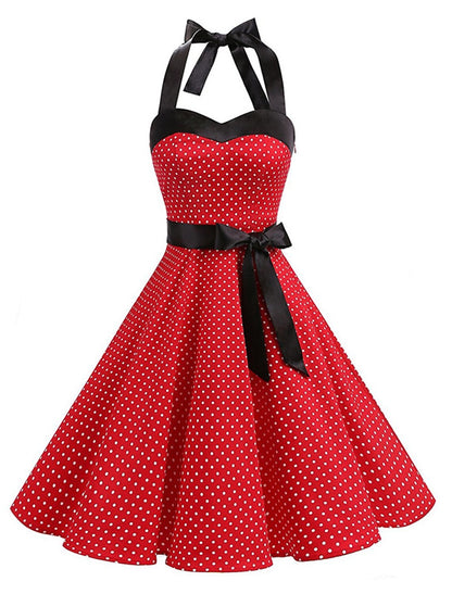 Woman wearing a red polka dot halter neck flare dress, side view.