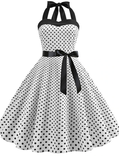 Woman posing in a red polka dot halter neck flare dress.