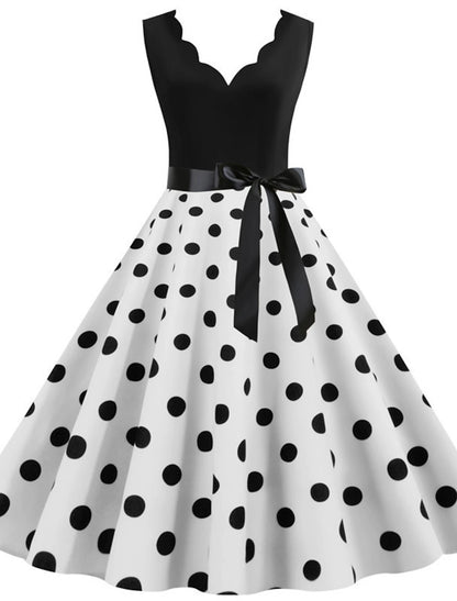 Woman wearing an elegant 1950s polka dot flare dress with a sweetheart neckline.