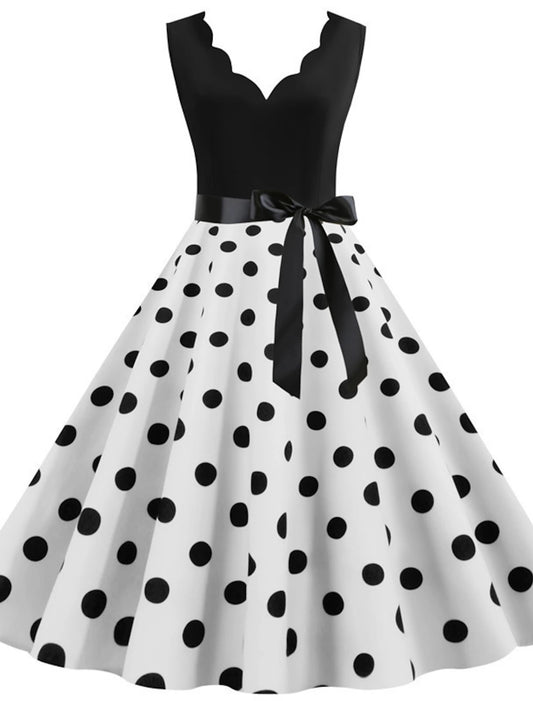 Woman wearing an elegant 1950s polka dot flare dress with a sweetheart neckline.
