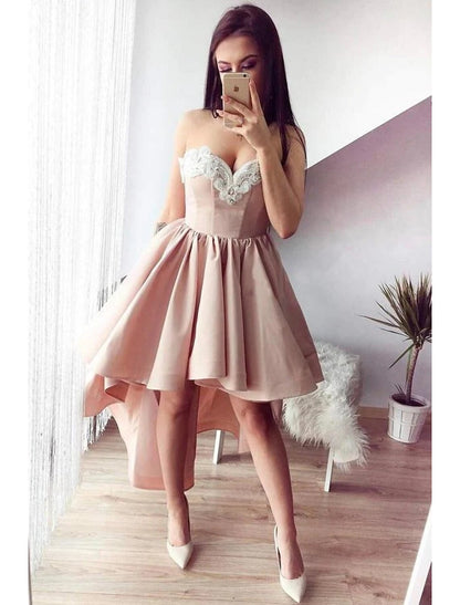 Woman wearing an elegant A-line satin cocktail dress with sweetheart neckline and appliques.