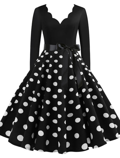 Woman wearing a black 1950s vintage A-line midi dress with a sweetheart neckline.
