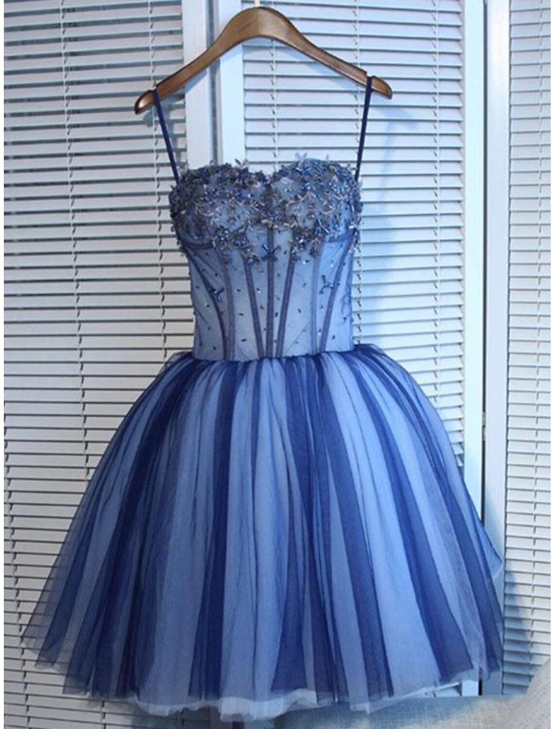 Side view of a short mini A-Line dress, showcasing tulle fabric and rhinestone embellishments.