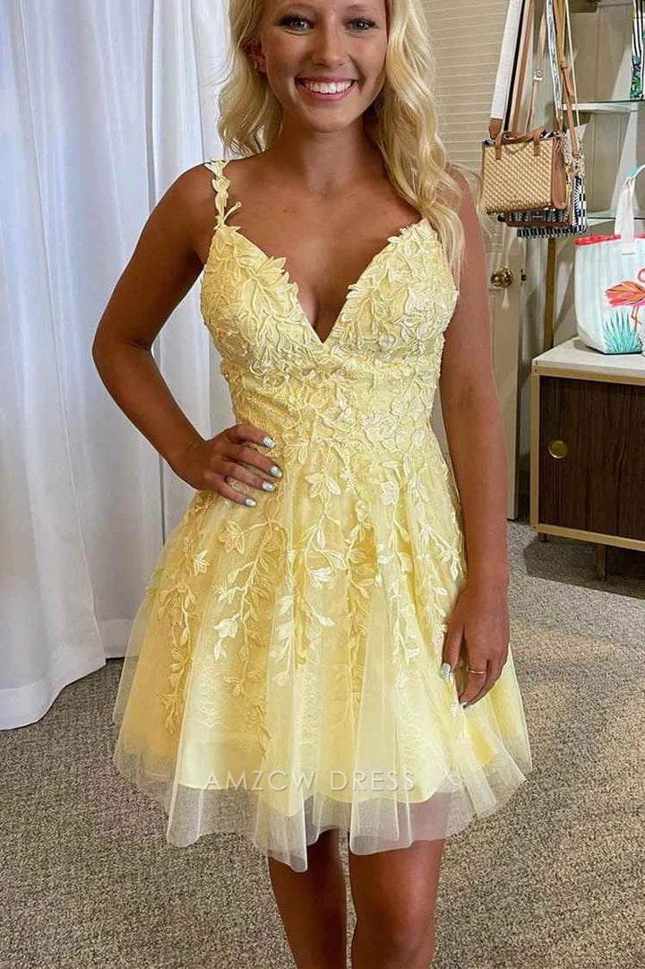 Back detail of light yellow V-neck dress with spaghetti straps and leaf embroidery.
