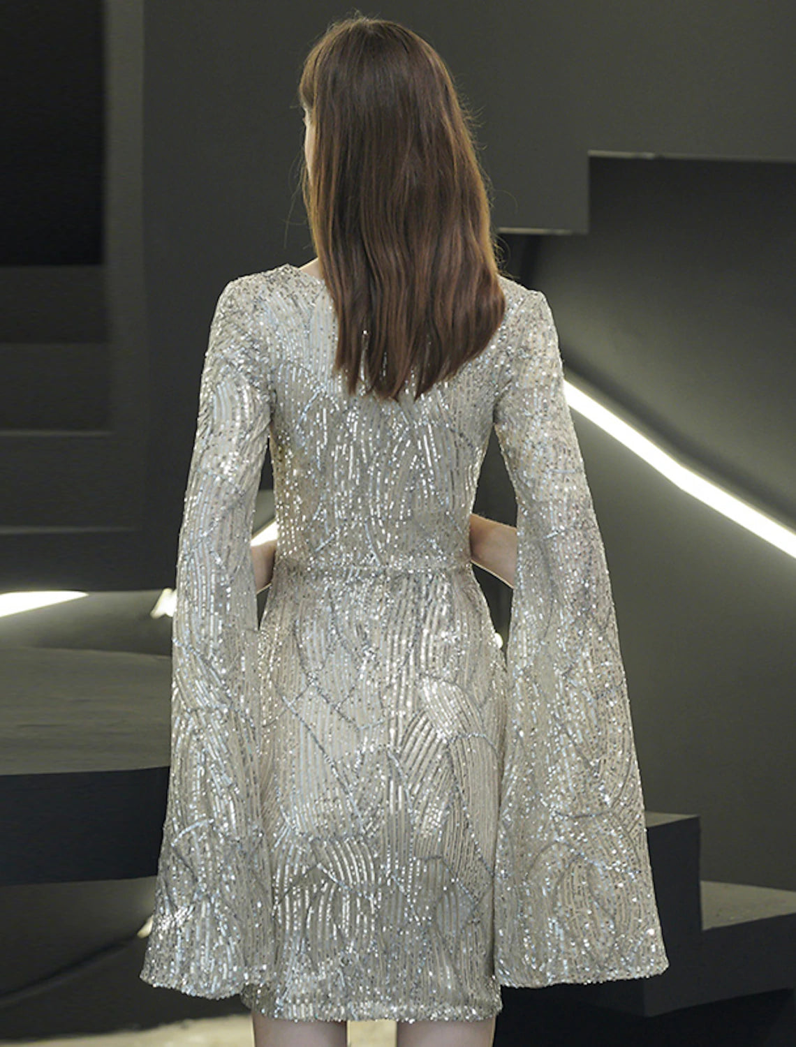 Close-up of the sparkling sequin fabric and V-neckline of the cocktail party dress.