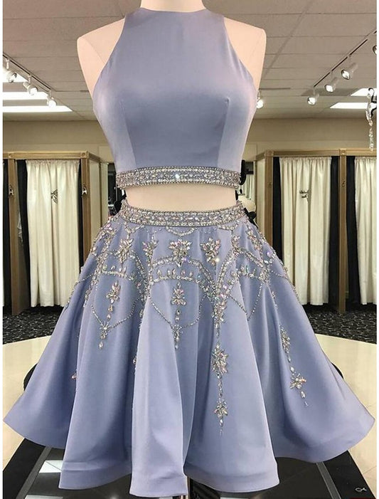 Model wearing a light blue two-piece homecoming dress with a beaded jewel neck top and a satin A-line mini skirt.