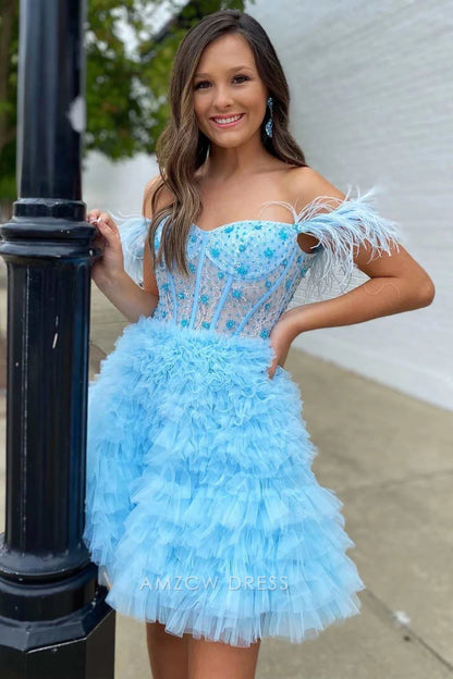 Close-up of light blue homecoming dress bodice with intricate beadwork, feather trim, and ruffled tulle.