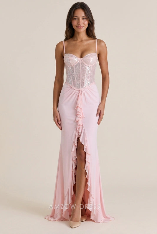 Model in a blush pink sequin mermaid prom dress with sweetheart neckline and ruffled high slit.