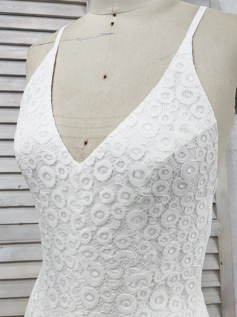 Vestido de fiesta de encaje blanco con escote en V profundo, tirantes cruzados, abertura y cola larga.