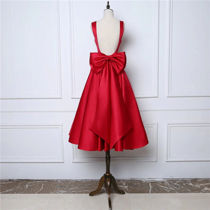 Vestidos de fiesta sexys con tirantes y espalda abierta de satén con lazo y largo hasta la rodilla 