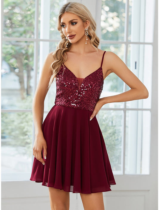 Model wearing a sparkling A-line mini homecoming dress with spaghetti straps.