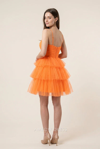 Back view of a model in a vibrant orange tiered short homecoming dress with spaghetti straps.