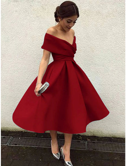 Full length view of a woman posing in a 1950s A-line tea length cocktail dress.
