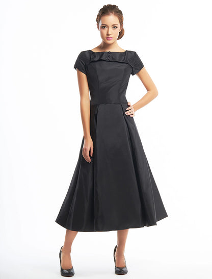 Vintage A-line tea length homecoming dress with short sleeves and boat neck.