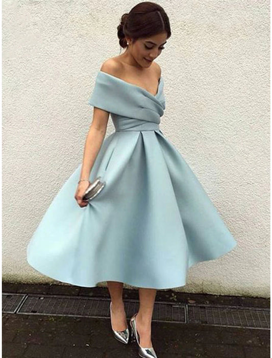 Woman wearing a vintage A-line V-neck short sleeve tea length cocktail dress with pleats.