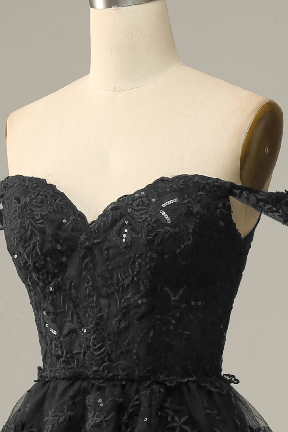 Vestido de fiesta negro con hombros descubiertos y capas 