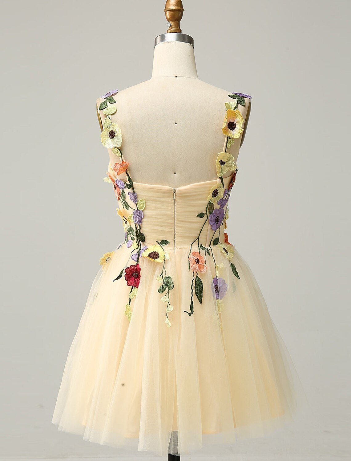 Side view of an A-line floral tulle cocktail dress with appliques.
