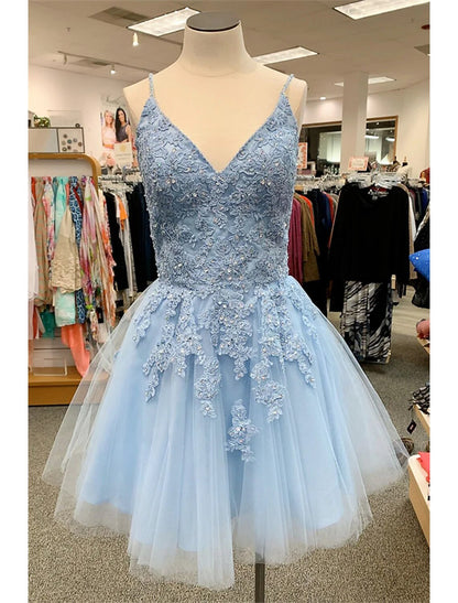 Model wearing a short A-line floral tulle homecoming dress with spaghetti straps and appliques.