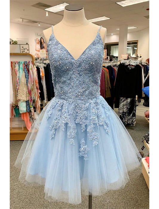 Model wearing a short A-line floral tulle homecoming dress with spaghetti straps and appliques.