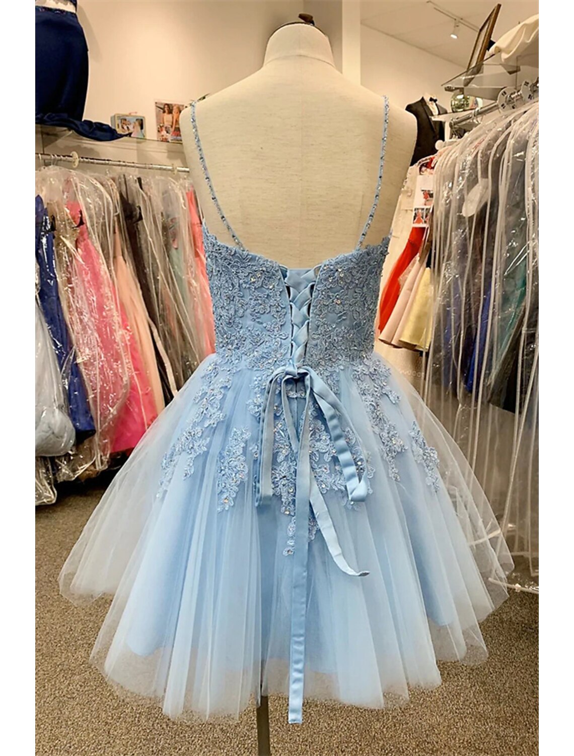 Back view of a model wearing a short A-line floral tulle party dress.