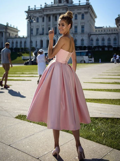 Back view of a tea-length sleeveless satin dress, perfect for homecoming.