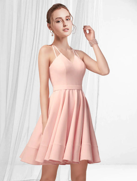 Model in A-line satin cocktail dress with spaghetti straps and pleats.