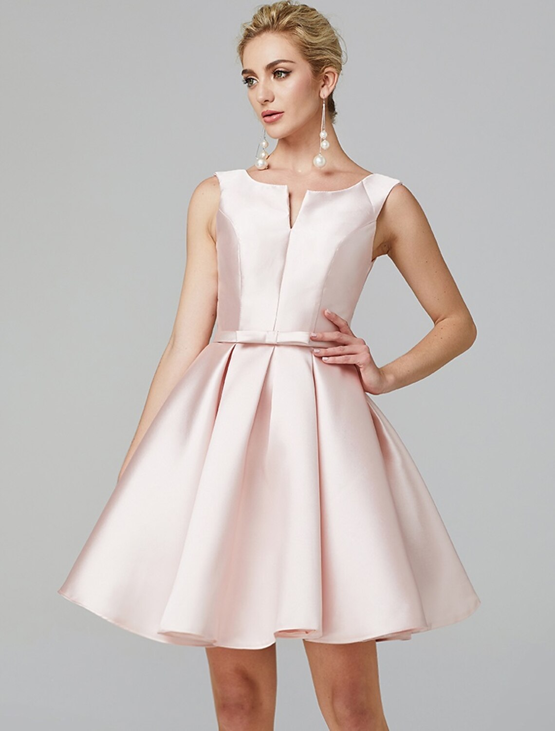 Close-up of the V-wire neckline and bow detail on a pink satin dress.