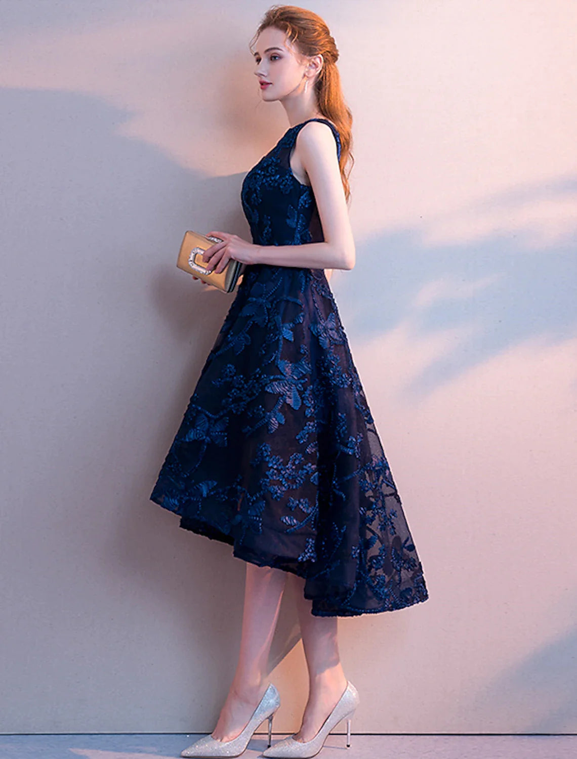 Full-length view of an A-line asymmetrical tulle cocktail dress.