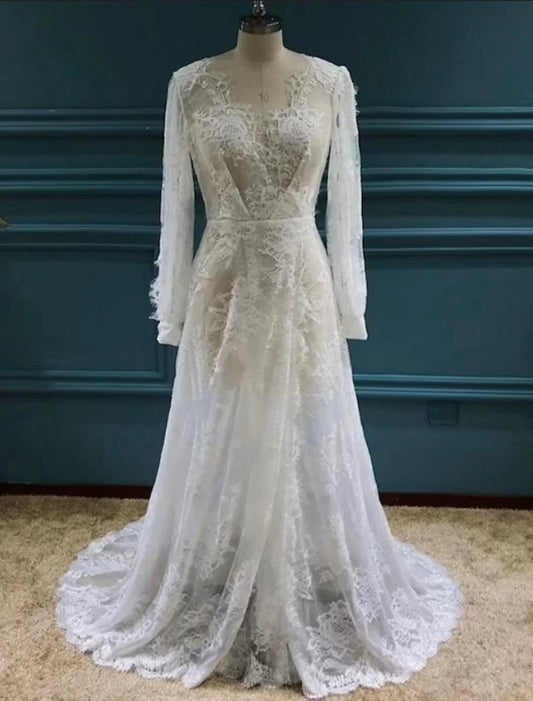 Model wearing a white Boho A-Line V-Neck long sleeve lace wedding dress with a split front.