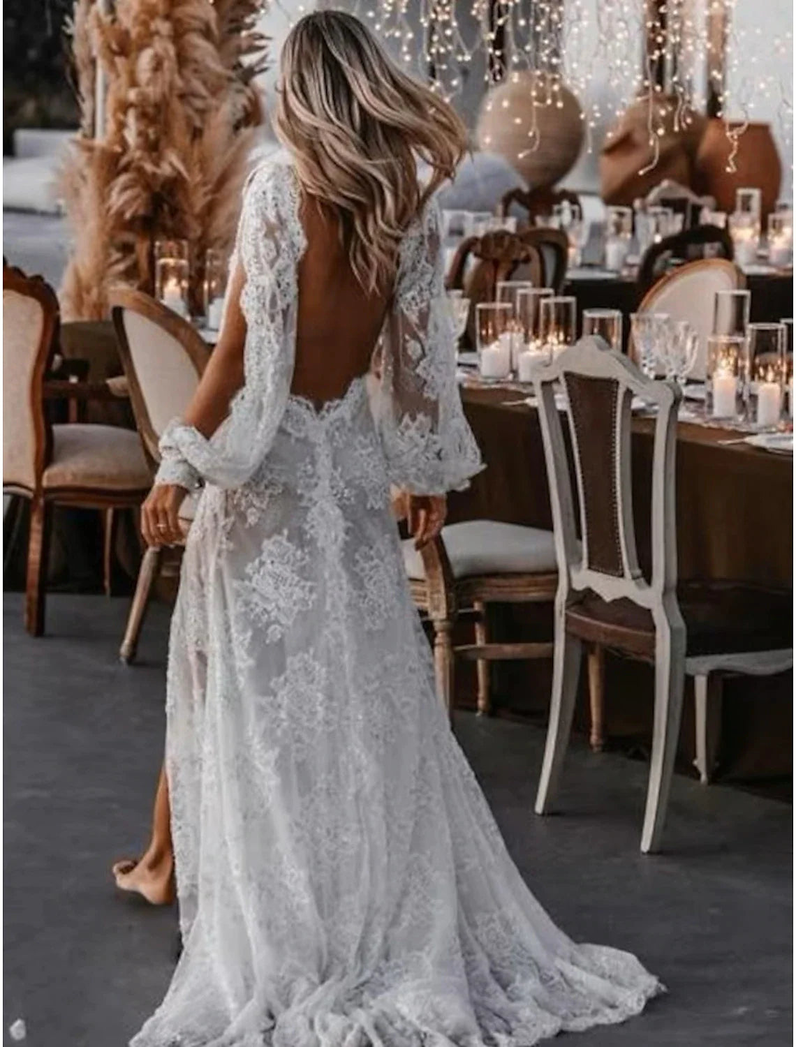 Detailed view of the long lace sleeves and delicate appliques on the bridal gown.