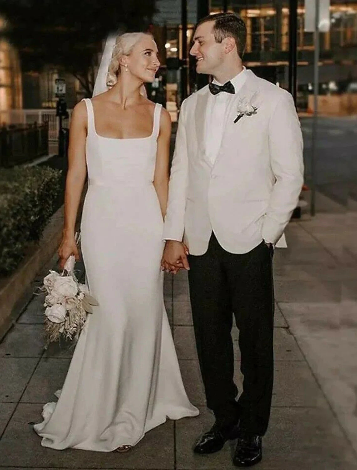 Bride in a white Boho Beach Mermaid Wedding Dress with camisole neckline and court train.