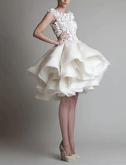 Side view of a model in a puffy tiered white organza dress with floral appliques.