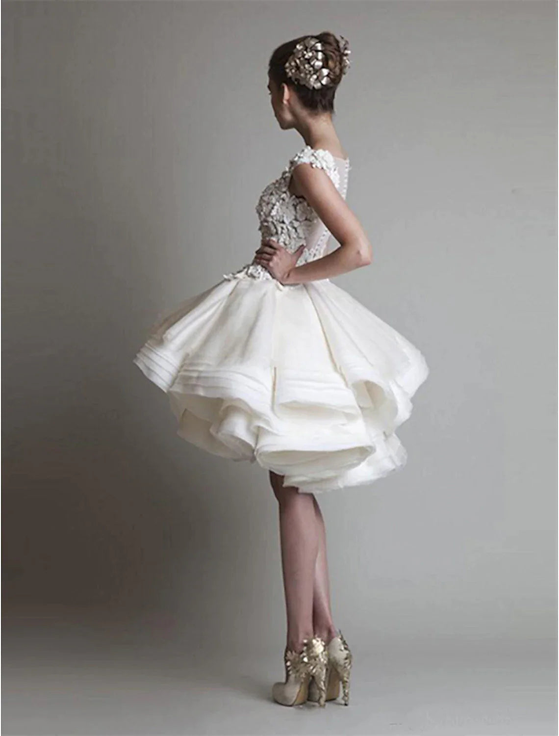Back view of a white short ball gown featuring delicate floral appliques.