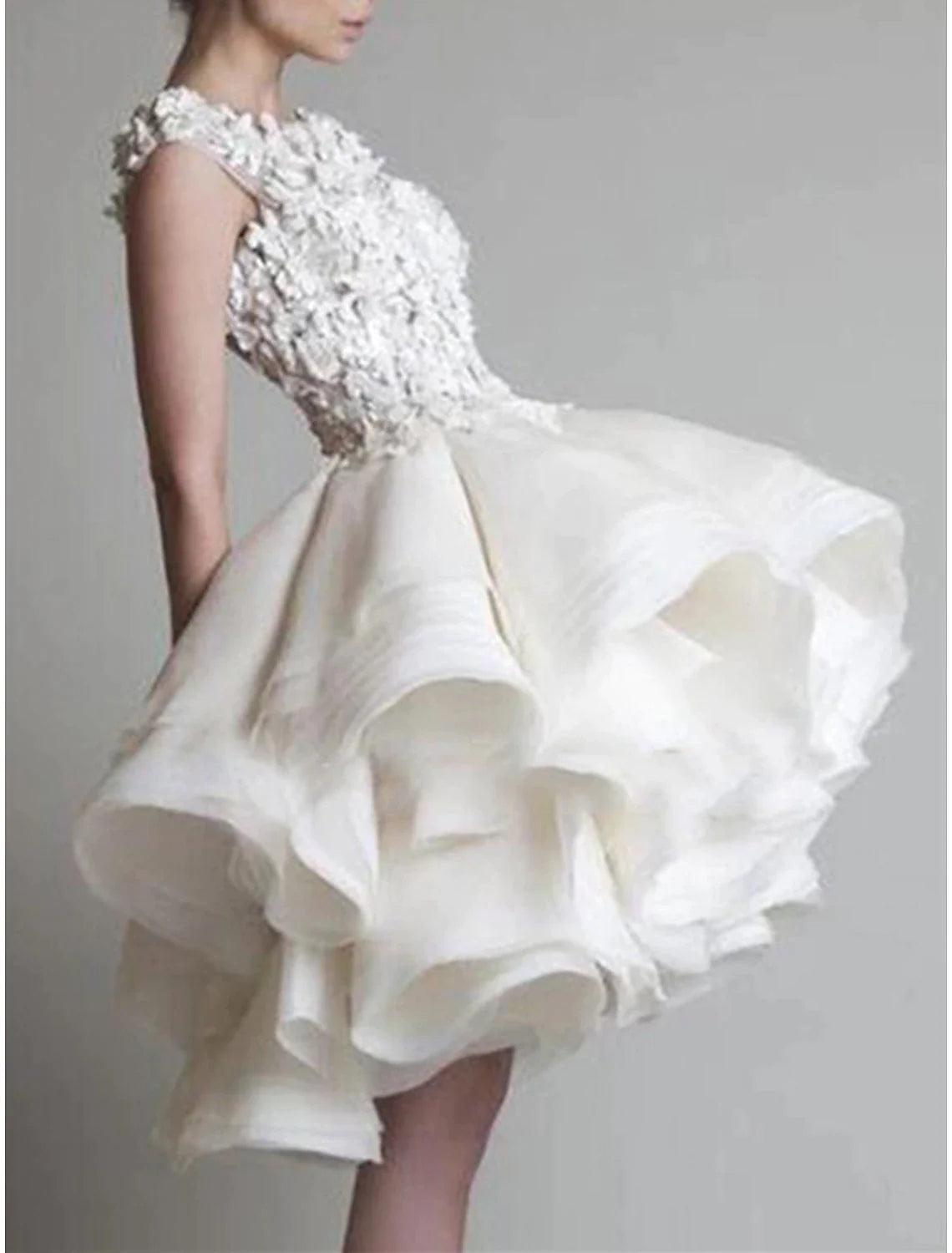 Close-up of the jewel neck and intricate floral appliques on the white dress.